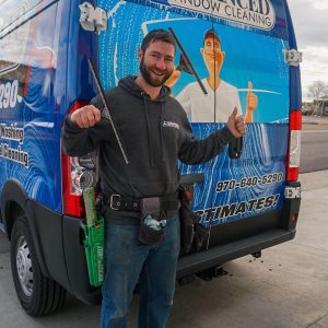 Advanced Window Cleaning professional with squeegee brush and work van